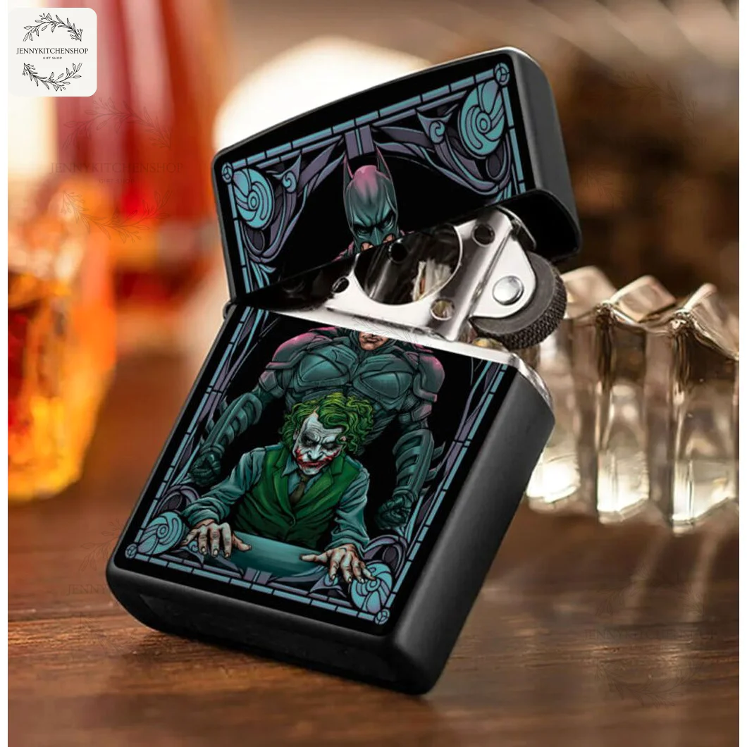 The Dark Knight lighter case open on a wood table, displaying the Batman and Joker artwork on the body and lid next to a drink.