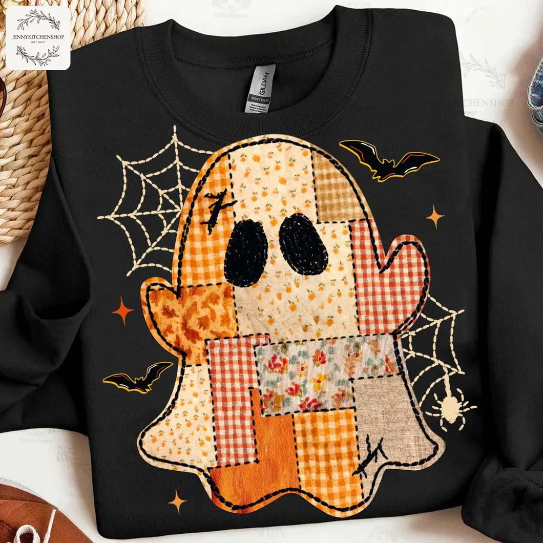 A black sweatshirt with a cute Halloween patchwork ghost graphic. The ghost has floral and plaid patterns with bats and webs.