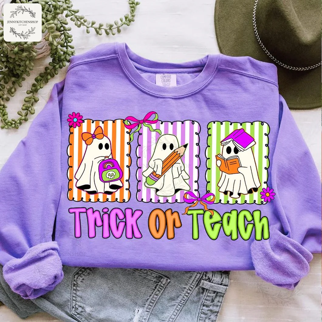 "Trick Or Teach" Halloween Teacher Sweatshirt in Purple A purple sweatshirt styled with jeans, showing the "Trick Or Teach" design with three adorable ghosts for a teacher's Halloween outfit.