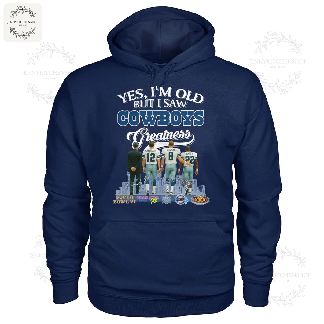 Front view of navy pullover hoodie displaying "Yes, I'm Old But I Saw Cowboys Greatness" artwork including coach and three players (Staubach #12, Aikman #8, Smith #22), skyline and Super Bowl badges
