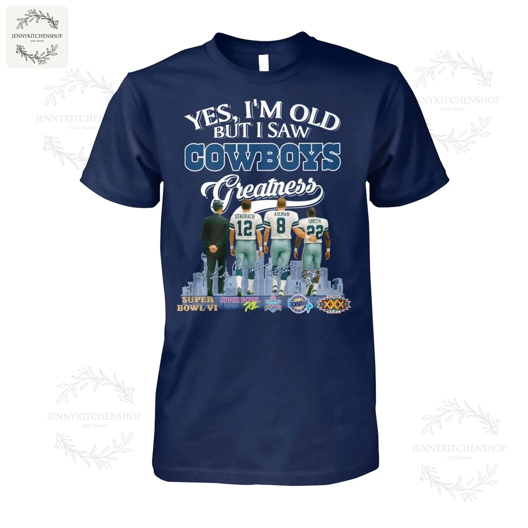 Front view of navy T‑shirt with "Yes, I'm Old But I Saw Cowboys Greatness" graphic showing coach and players Staubach #12, Aikman #8, Smith #22 from the back, city skyline and Super Bowl logos