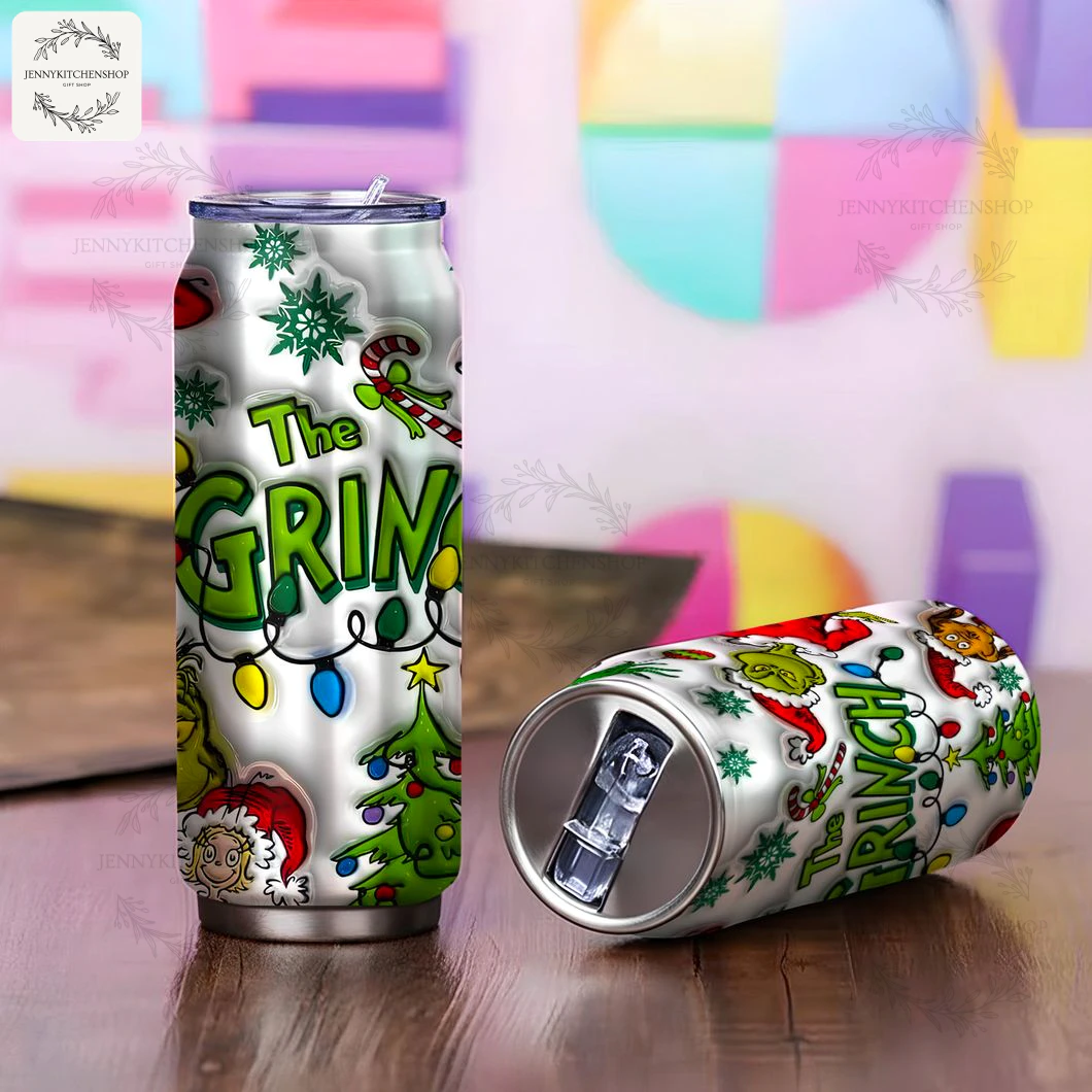 Two Grinch x Christmas Can Shaped Tumblers in a Colorful Setting One Grinch can tumbler standing upright and another lying down, displaying the vibrant Christmas design on a wooden table.