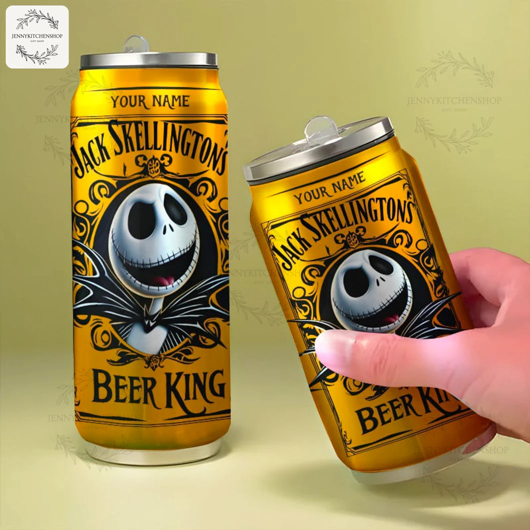 Jack Skellington New Can Tumbler — Handheld & Pair View Two gold Jack Skellington can tumblers on a neutral surface, one upright and one tilted and held by a hand to show scale, showcasing the front artwork, "Beer King" text and customizable name area.