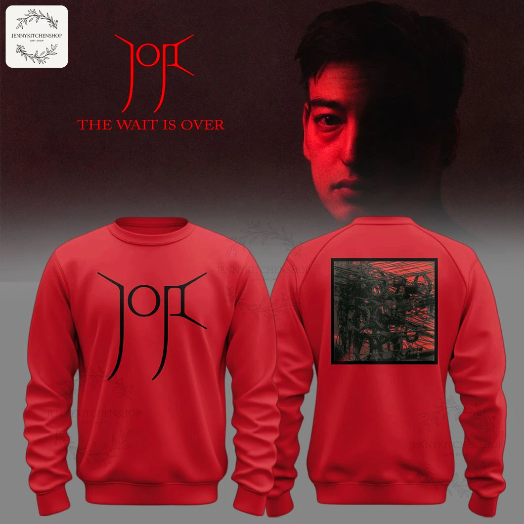A mockup of the red Joji New Single 'The Wait Is Over' sweatshirt, showing the front with a stylized logo and the back with a graphic.