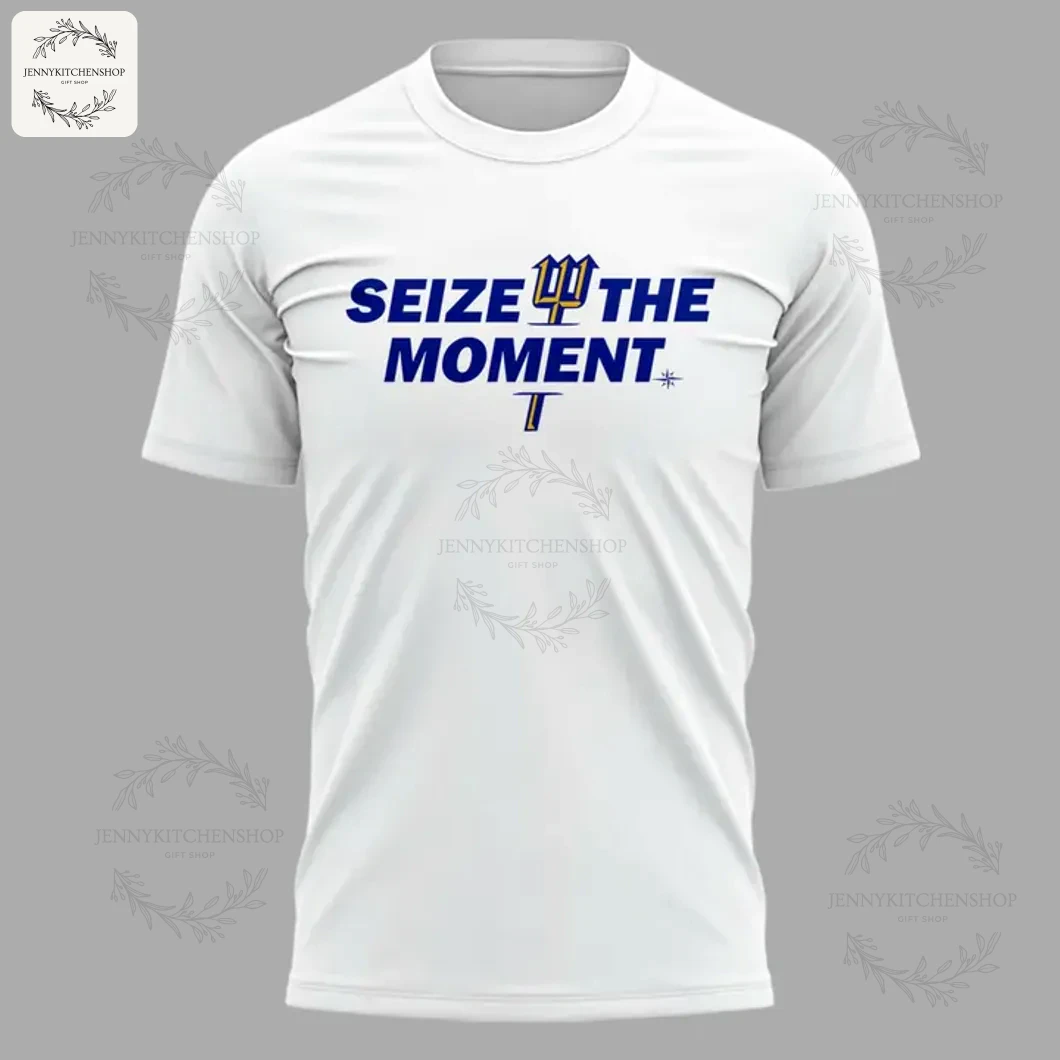 Close-up of the front of a white t-shirt with blue text reading Seize The Moment and the Mariners trident logo.